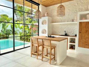 a kitchen with a table and chairs and a swimming pool at The Suites by The Young Villas in Uluwatu