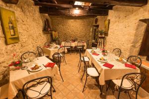 un comedor con mesas y sillas blancas en Nenà Al Borgo Castello, en Pico