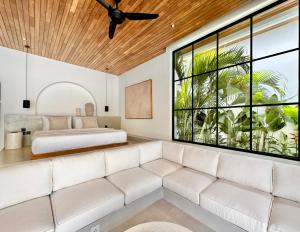 ein Wohnzimmer mit einem Sofa und einem Bett in der Unterkunft The Suites by The Young Villas in Uluwatu
