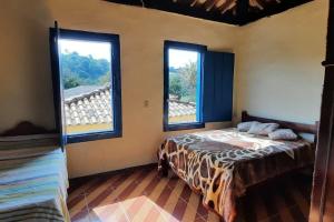 Ένα ή περισσότερα κρεβάτια σε δωμάτιο στο Santa Lucia Fazenda Centenária nas Montanhas