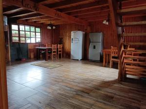 een keuken met 2 koelkasten en een tafel en stoelen bij Hostel Calafquen Coñaripe in Coñaripe