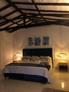 Un dormitorio con una cama con dos luces. en Rustico Hostel Barichara en Barichara