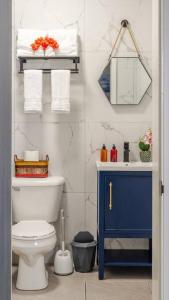 uma casa de banho com um WC e um armário azul em Thatch Garden Apartment em Long Bay Village