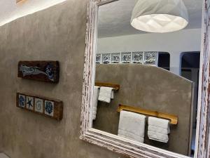 a mirror in a bathroom with towels in it at Oca House in Búzios