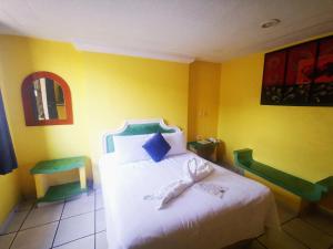 ein Schlafzimmer mit einem weißen Bett und einer gelben Wand in der Unterkunft Casa Real in Poza Rica de Hidalgo + 8 Fotos