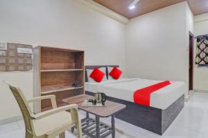 a bedroom with a bed and a table and a chair at OYO Flagship Rks Residency in Shamshabad