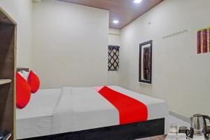 a white bedroom with a red and white bed at OYO Flagship Rks Residency in Shamshabad