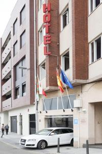 un coche blanco estacionado frente a un hotel en Hotel Besaya, en Torrelavega