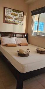 a bed with two baskets on top of it at Discover the charm of this homely villa just a stone's throw from the beach in Bauang
