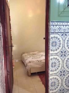 um pequeno quarto com uma cama no canto de um quarto em Moroccan Family House em Agadir