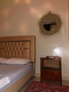 een slaapkamer met een bed, een spiegel en een tafel bij Moroccan Family House in Agadir