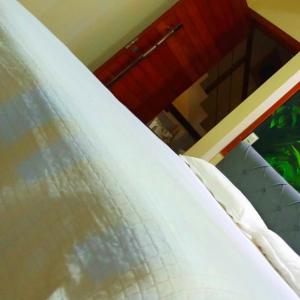 einem Bett mit weißer Bettwäsche in der Unterkunft Casa em Milagres in São Miguel dos Milagres