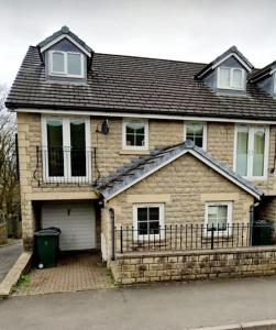 a brick house with a fence in front of it at 9 Guest 7 Beds Lovely House in Rossendale in Newchurch