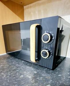 a microwave on a counter with a wooden handle at 9 Guest 7 Beds Lovely House in Rossendale in Newchurch