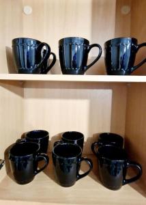 a row of black cups on a shelf at 9 Guest 7 Beds Lovely House in Rossendale in Newchurch