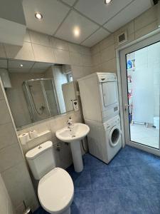 La salle de bains est pourvue d'un lavabo et d'un lave-linge. dans l'établissement - SERENITY Apartment -, à Skopje
