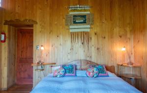 a bedroom with a blue bed with wooden walls at Zapato Amarillo Bed & Breakfast in Puerto Octay