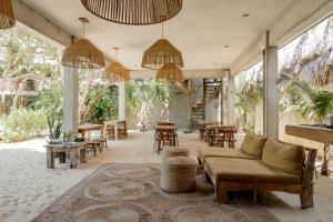 ein Wohnzimmer mit Sofa, Stühlen und Tischen in der Unterkunft Villa Mango Jeri in Jericoacoara