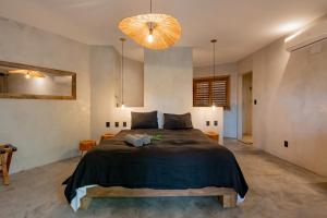 ein Schlafzimmer mit einem großen Bett und einem Kronleuchter in der Unterkunft Villa Mango Jeri in Jericoacoara