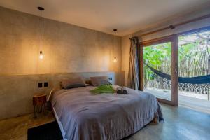 a bedroom with a large bed and a large window at Villa Mango Jeri in Jericoacoara