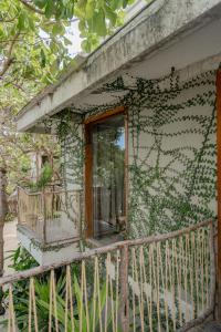 a building covered in ivy with a window and a balcony at Villa Mango Jeri in Jericoacoara