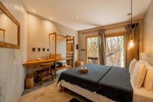 a bedroom with a bed and a desk and a window at Villa Mango Jeri in Jericoacoara