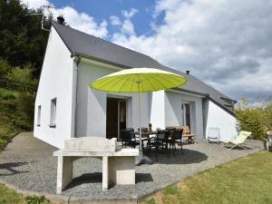 a yellow umbrella in front of a white building at Family Stay in Normandy in Villedieu-les-Poëles