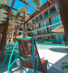 uma cadeira e um guarda-sol junto a uma piscina em Sunny Hall Acqua com piscina privativa em Porto de Galinhas