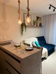 a kitchen with a counter with wine glasses and a couch at Sunny Hall Acqua com piscina privativa in Porto De Galinhas