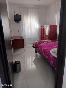 1 dormitorio con 1 cama y TV. en Residencia MJN en Chignahuapan