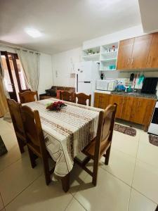 a dining room table with chairs and a kitchen at Aluguel Apto. Triplex Guaramiranga. in Guaramiranga