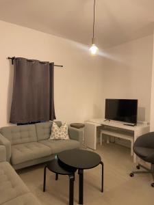 a living room with a couch and a tv at AptStays in Cardiff