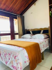 a bedroom with two beds and a window at Aluguel Apto. Triplex Guaramiranga. in Guaramiranga