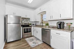 uma cozinha com armários brancos e um frigorífico de aço inoxidável em Private Suite in Upscale Neighborhood em Huntsville