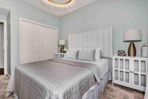 um quarto branco com uma cama e um lustre em Private Suite in Upscale Neighborhood em Huntsville