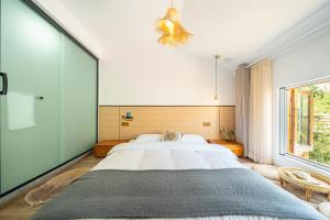 um quarto com uma cama grande e uma janela grande em 小喜屋（西井街店） em Qingpu