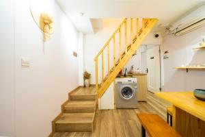 a washing machine in a laundry room with a staircase at 小喜屋（西湖街店） in Qingpu