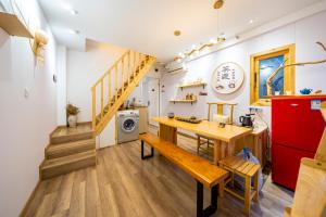 a kitchen with a wooden table and a red refrigerator at 小喜屋（西湖街店） in Qingpu