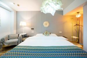 a bedroom with a large white bed and a chair at 小喜屋（西湖街店） in Qingpu