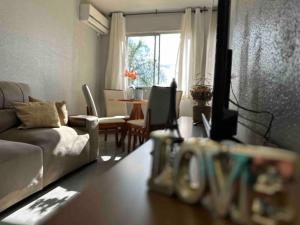 克里西烏馬的住宿－Apartamento há 5 min do Centro de Criciúma.，客厅配有沙发和电视。