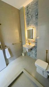 Baño blanco con lavabo y aseo en Cozy apartment in down town en El Cairo