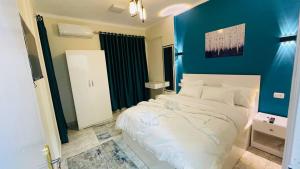 um quarto com uma cama branca e uma parede azul em Cozy apartment in down town em Cairo