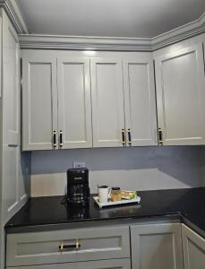 a kitchen with white cabinets and a black counter top at Secret Hideaway in Ocho Rios