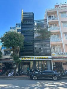 een zwarte auto geparkeerd voor een gebouw bij LION 9 HOTEL in Can Tho