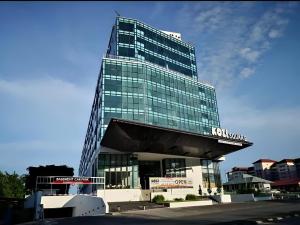 a tall glass building with a sign in front of it at Kuching Kozi Square Homestay Apartment in Kuching