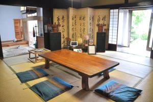 a living room with a wooden table and two mats at Private stay 120years old Japanese-style house in Okinoshima