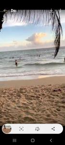 een foto van het strand met mensen in de oceaan bij Homestay Mia Diệu Nhàn Phú Quốc in Phu Quoc