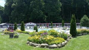 a garden with flowers and a swimming pool at A Holiday Motel - Maggie Valley in Maggie Valley