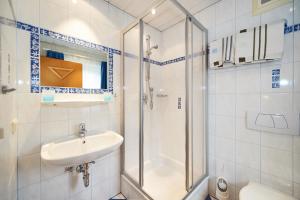 a white bathroom with a shower and a sink at Bauernhof Auhof in Wagrain +113 photos