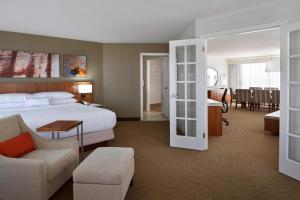 a hotel room with a bed and a dining room at Delta Hotels by Marriott Toronto Airport & Conference Centre in Toronto +62 photos